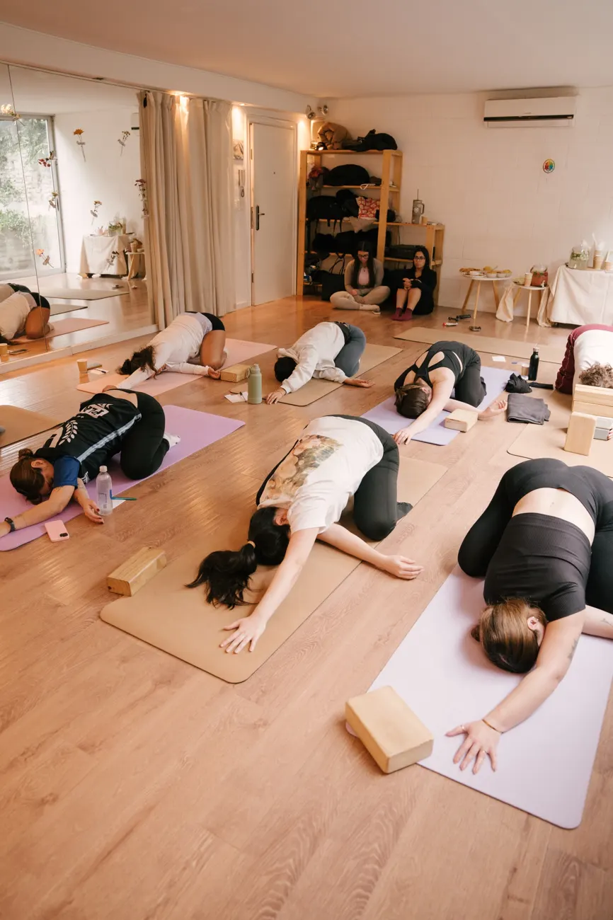 Participantes en postura del niño sobre mats de yoga